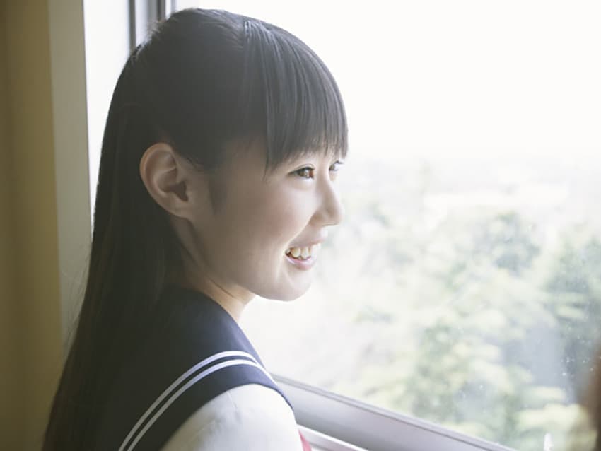窓から外を見る女子中学生